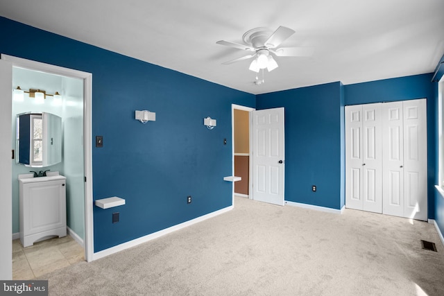 unfurnished bedroom featuring baseboards, visible vents, carpet floors, and a sink