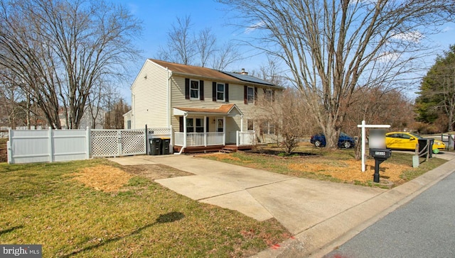 view of front of house with a front yard, fence, solar panels, a chimney, and concrete driveway