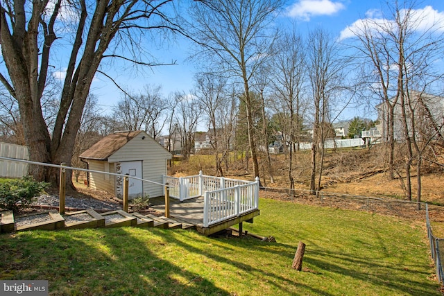 view of yard featuring a wooden deck, an outdoor structure, and fence