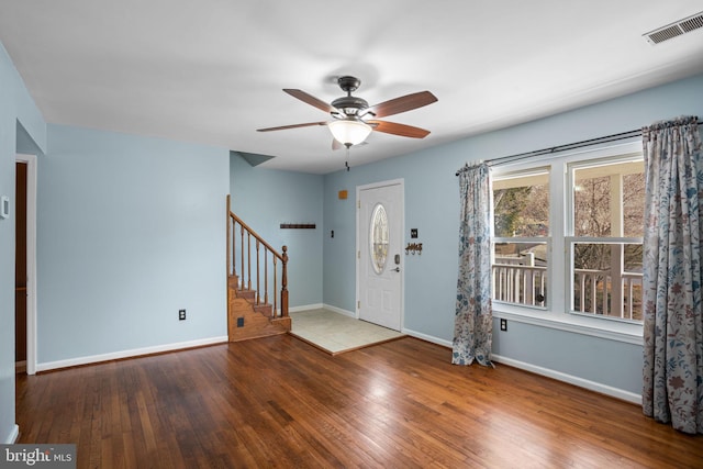 foyer with hardwood / wood-style floors, stairway, a ceiling fan, baseboards, and visible vents