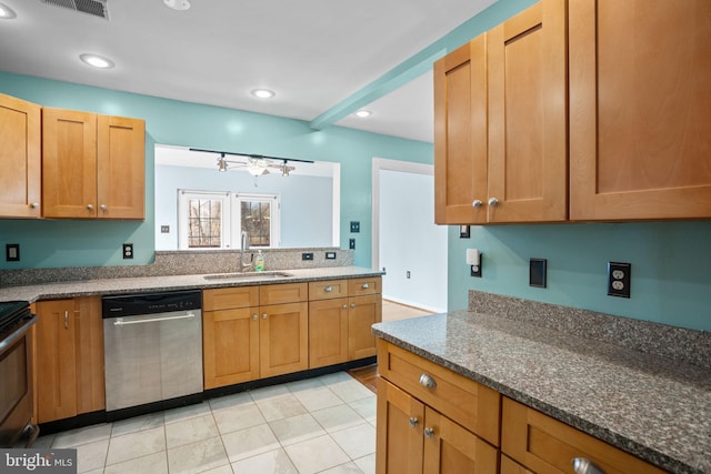 kitchen featuring dark stone countertops, recessed lighting, appliances with stainless steel finishes, and a sink