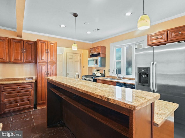 kitchen with a sink, appliances with stainless steel finishes, crown molding, brown cabinetry, and hanging light fixtures