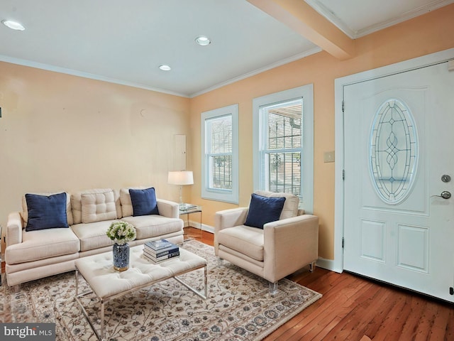 interior space with beam ceiling, ornamental molding, baseboards, and wood finished floors