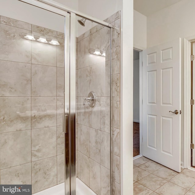 full bathroom featuring tile patterned floors and a shower stall