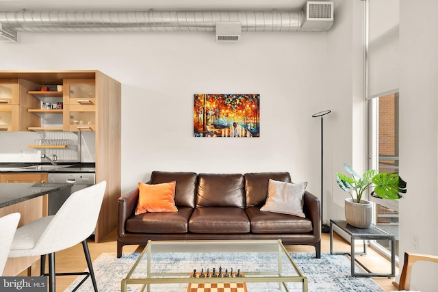 living room with visible vents and light wood-style flooring