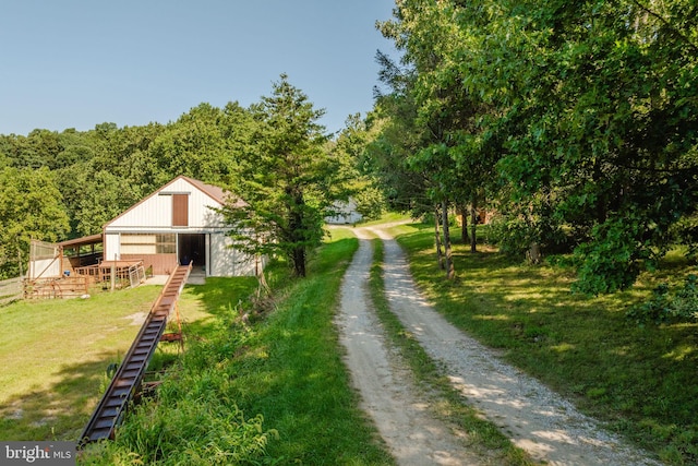 view of yard featuring an outbuilding, driveway, and an outdoor structure