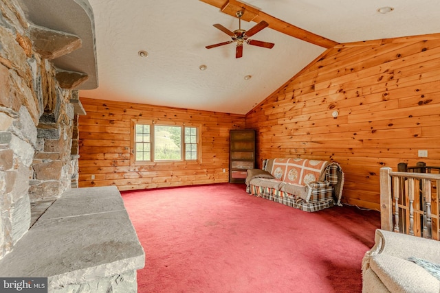 living room with vaulted ceiling with beams, wood walls, ceiling fan, and carpet floors