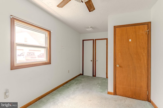 unfurnished bedroom with ceiling fan, carpet flooring, and baseboards