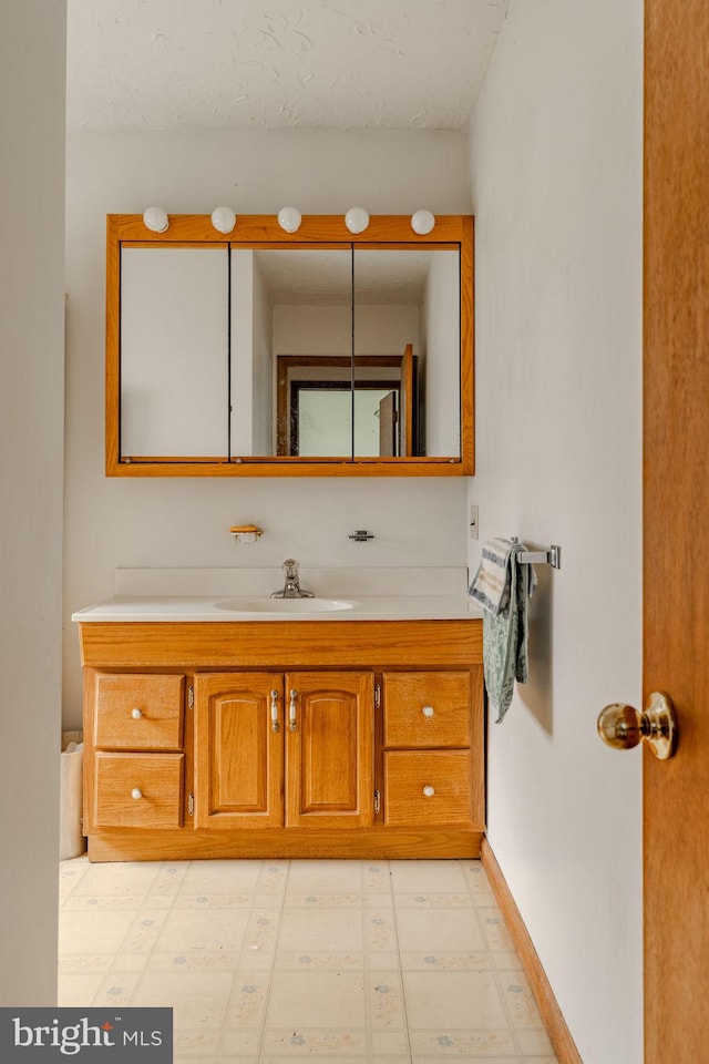 bathroom featuring vanity, baseboards, and tile patterned floors