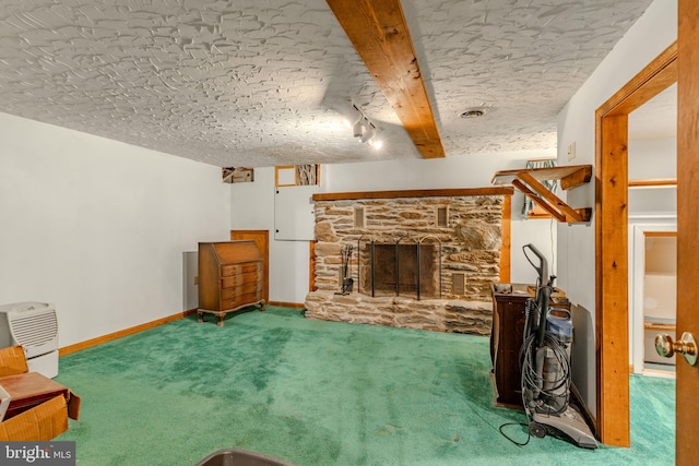 carpeted living area featuring a textured ceiling, a stone fireplace, visible vents, baseboards, and beam ceiling