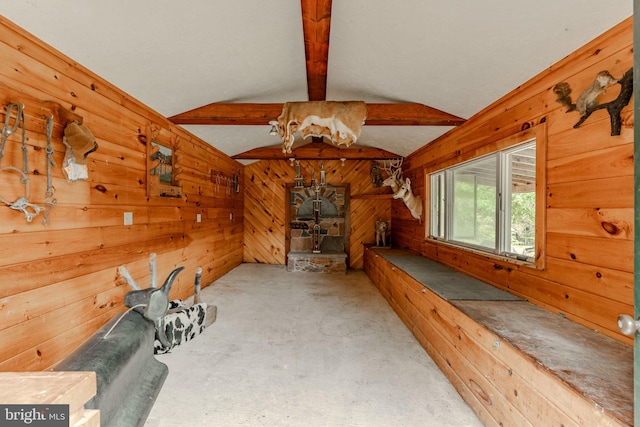 exercise room featuring vaulted ceiling and wood walls