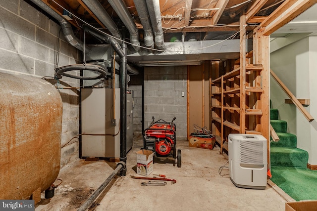 unfinished below grade area featuring heating unit, heating fuel, and stairs