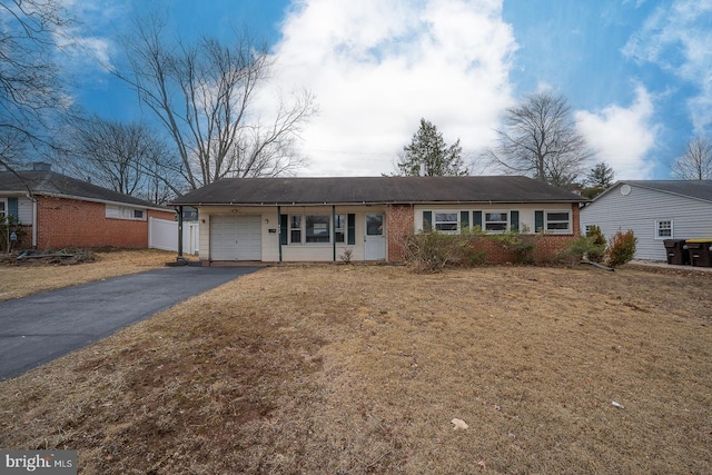 single story home featuring a garage, brick siding, and driveway