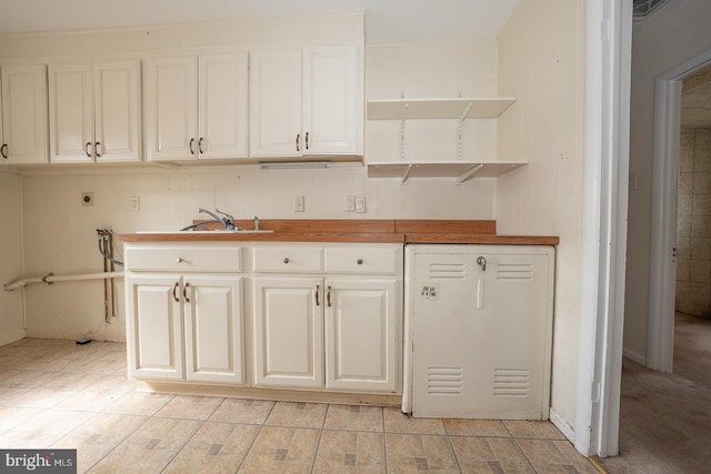 kitchen with white dishwasher, white cabinetry, open shelves, and refrigerator