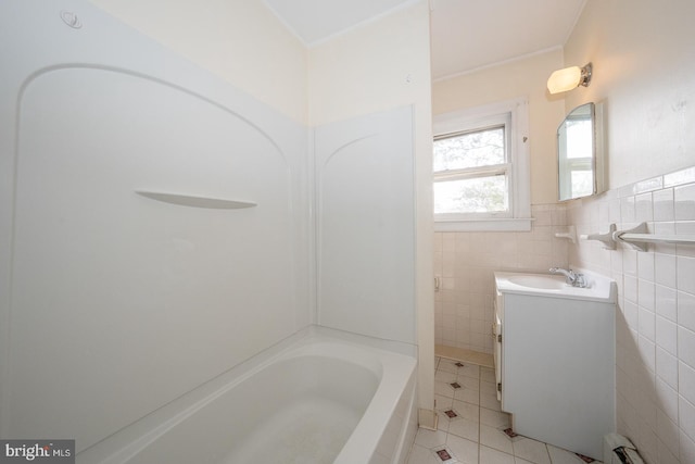 bathroom with a wainscoted wall, tile walls, baseboard heating, vanity, and tile patterned floors