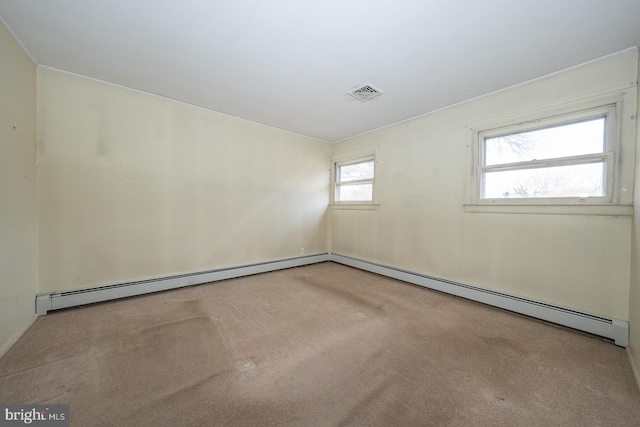 carpeted empty room featuring a baseboard radiator and visible vents