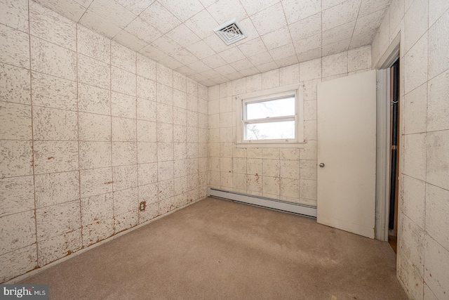 spare room featuring a baseboard heating unit and visible vents