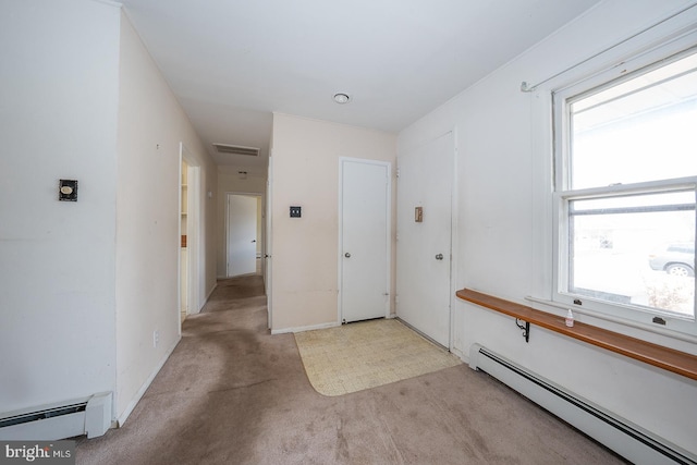 foyer entrance with a baseboard radiator, carpet flooring, visible vents, and baseboards