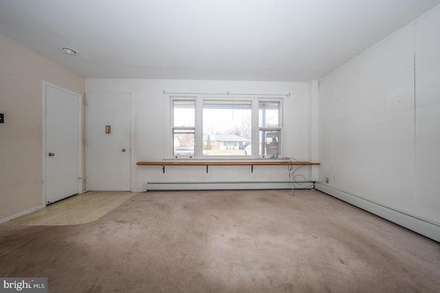 carpeted spare room featuring a baseboard heating unit and a baseboard radiator