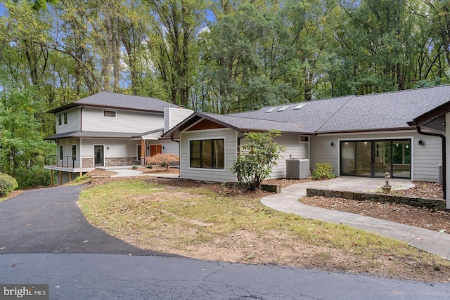 split level home with central AC and stone siding