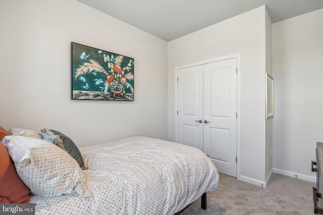 bedroom featuring a closet, baseboards, and carpet flooring