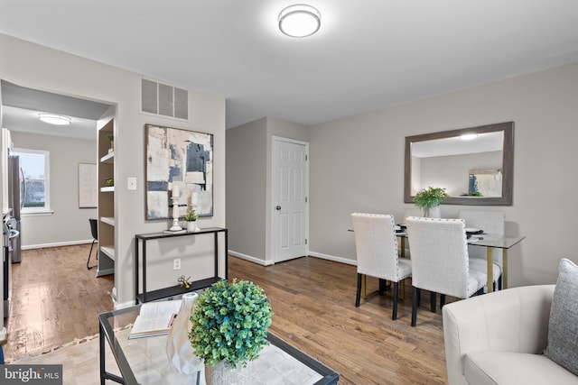 interior space with visible vents, baseboards, and wood finished floors