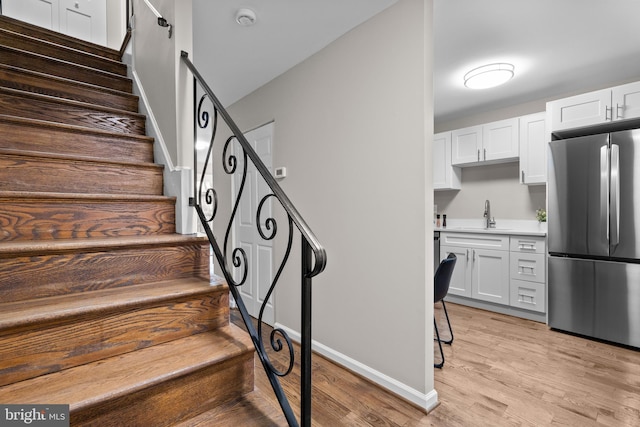 staircase featuring baseboards and wood finished floors