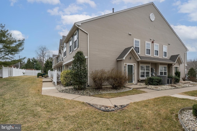 view of side of property with fence and a yard