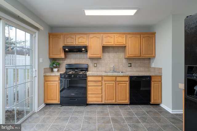 kitchen with baseboards, decorative backsplash, under cabinet range hood, black appliances, and a sink