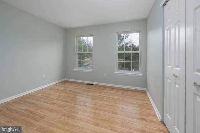 empty room with light wood-type flooring and baseboards