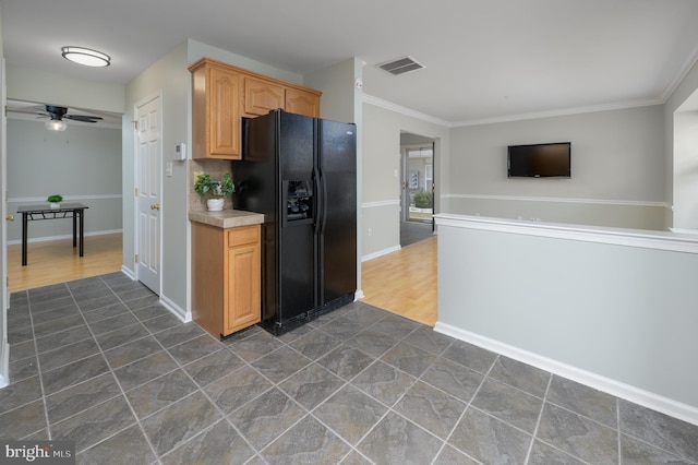 kitchen with baseboards, visible vents, ceiling fan, black refrigerator with ice dispenser, and light countertops