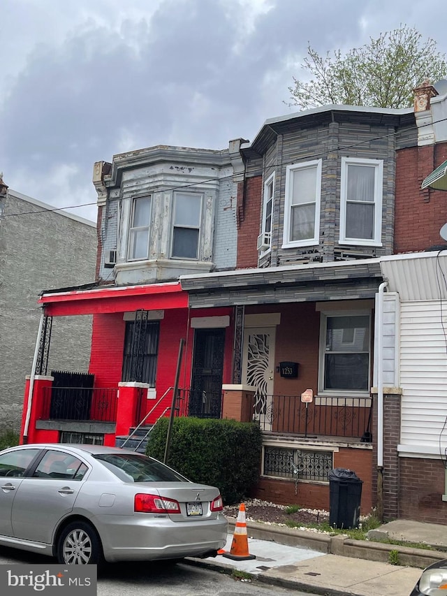 multi unit property with a porch and brick siding