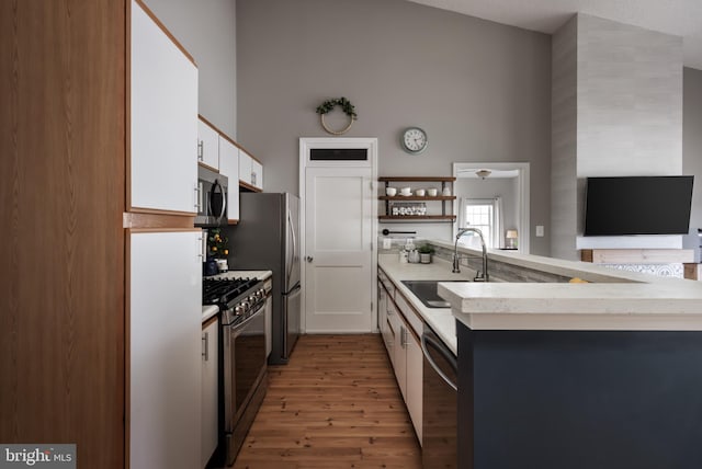 665 Constellation Sq SE Unit F, Leesburg, VA 20175 - kitchen featuring stainless steel appliances, a sink, light wood finished floors, white cabinets, and a peninsula