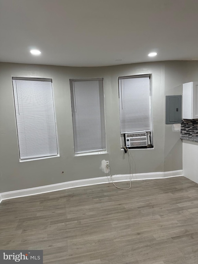 unfurnished room featuring recessed lighting, light wood-type flooring, electric panel, and baseboards