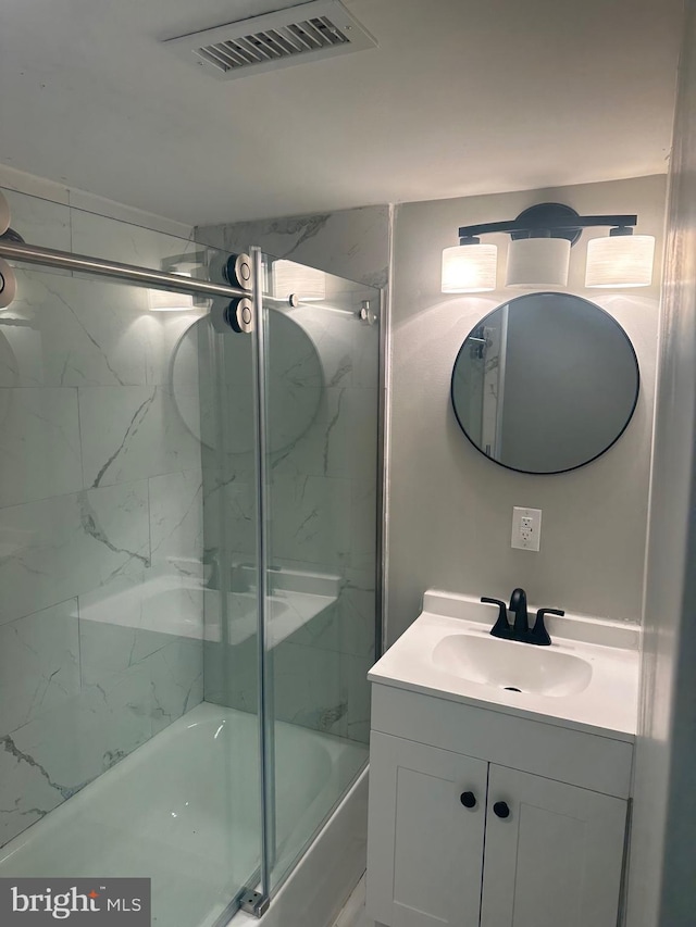 bathroom with visible vents, combined bath / shower with glass door, and vanity