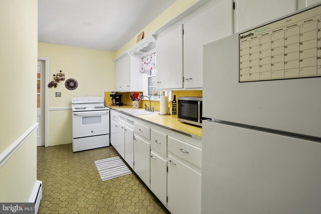 kitchen with white appliances, white cabinetry, light countertops, and a sink