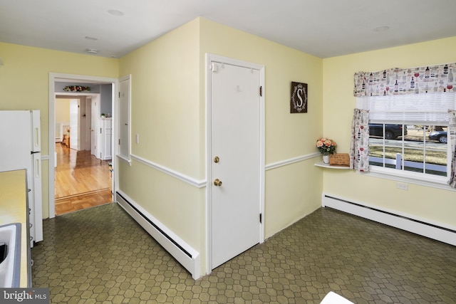 hall with a baseboard radiator and dark floors