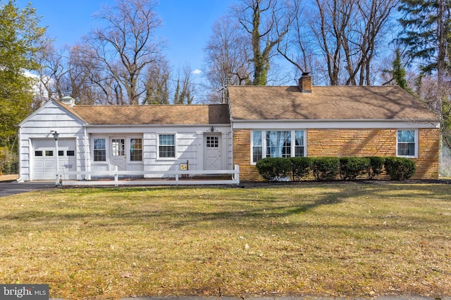 view of front facade featuring a chimney, aphalt driveway, an attached garage, a front lawn, and brick siding