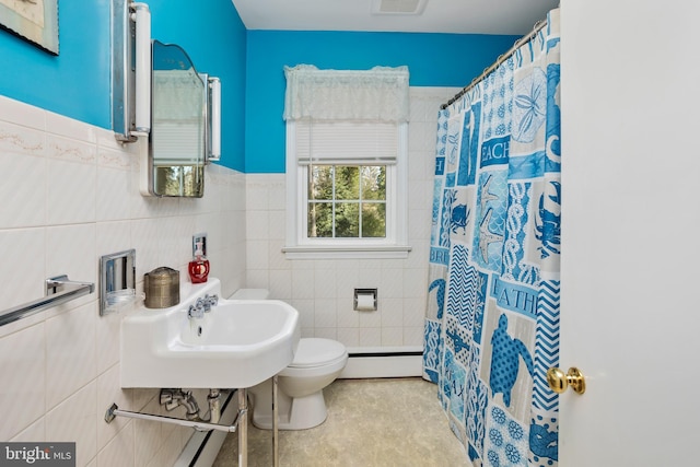 bathroom with tile walls, visible vents, toilet, a baseboard heating unit, and a sink