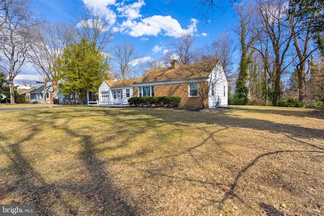 view of front of property featuring a chimney and a front lawn