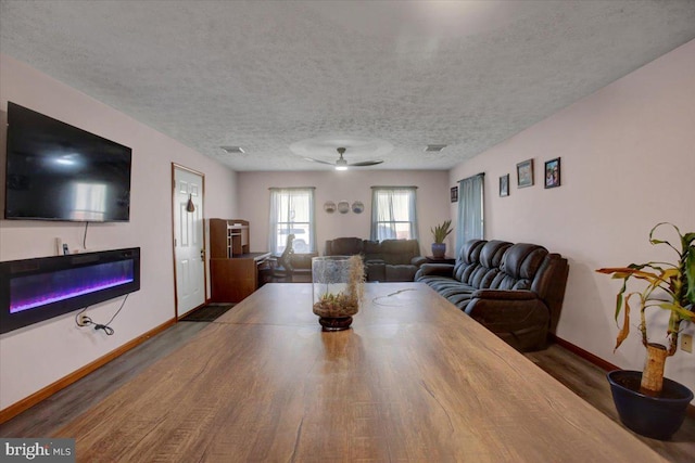 dining space featuring visible vents, baseboards, a textured ceiling, and wood finished floors