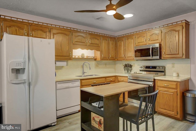 kitchen with visible vents, light wood-style flooring, a sink, appliances with stainless steel finishes, and light countertops