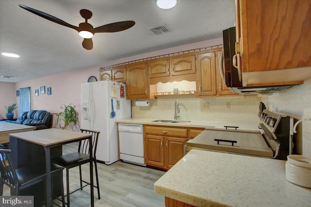 kitchen with white appliances, visible vents, a sink, light countertops, and light wood-type flooring