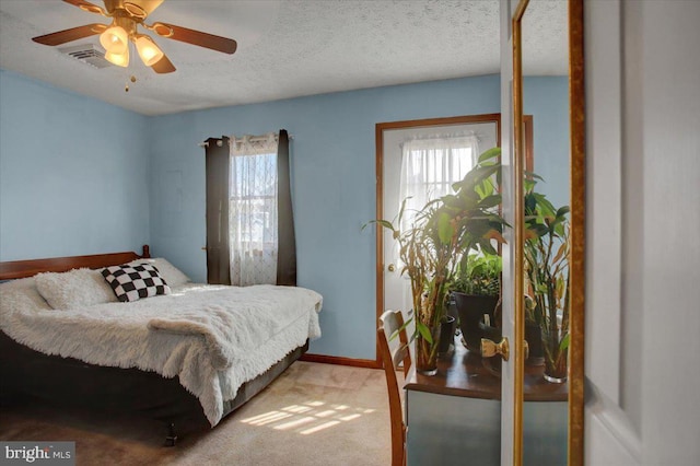 bedroom featuring carpet flooring, multiple windows, visible vents, and a textured ceiling