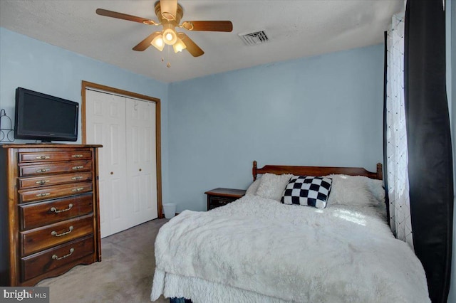 carpeted bedroom with visible vents, a closet, and ceiling fan