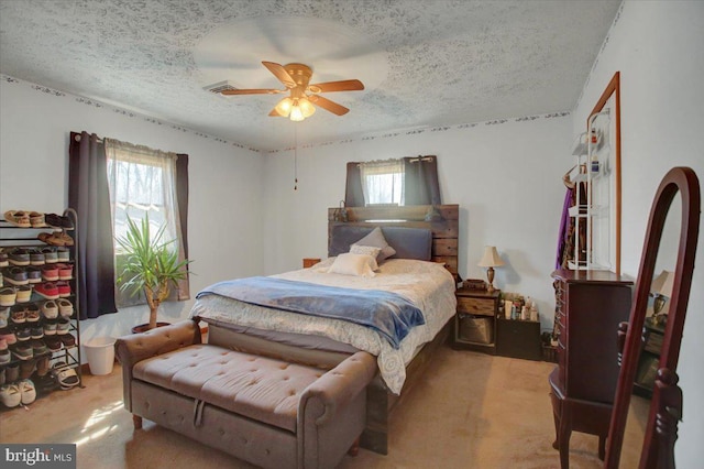 bedroom with multiple windows, a textured ceiling, and carpet flooring