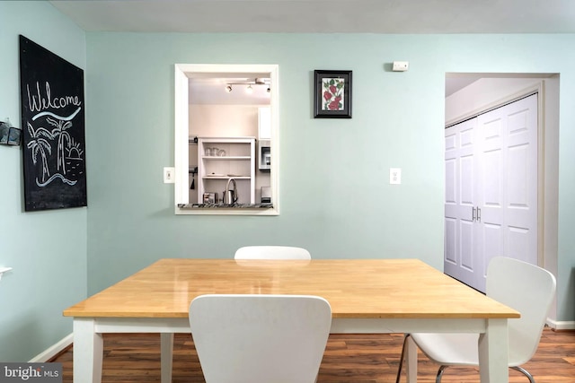 dining area featuring wood finished floors and baseboards