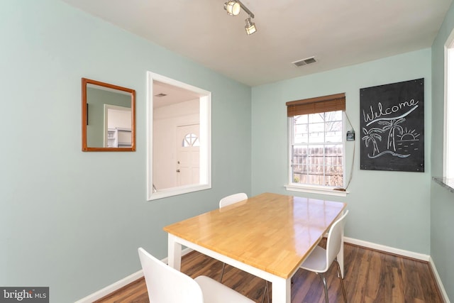 dining space with visible vents, baseboards, and wood finished floors