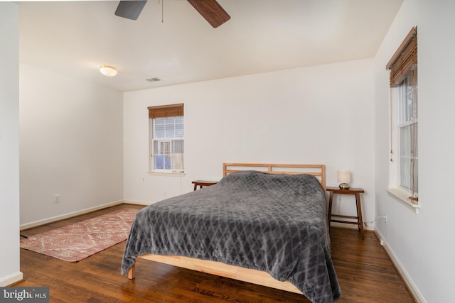 bedroom with baseboards, ceiling fan, visible vents, and hardwood / wood-style floors