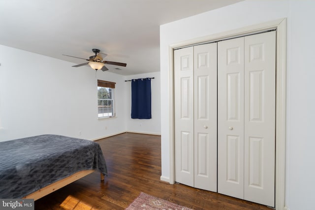 bedroom featuring a closet, dark wood-style flooring, baseboards, and a ceiling fan